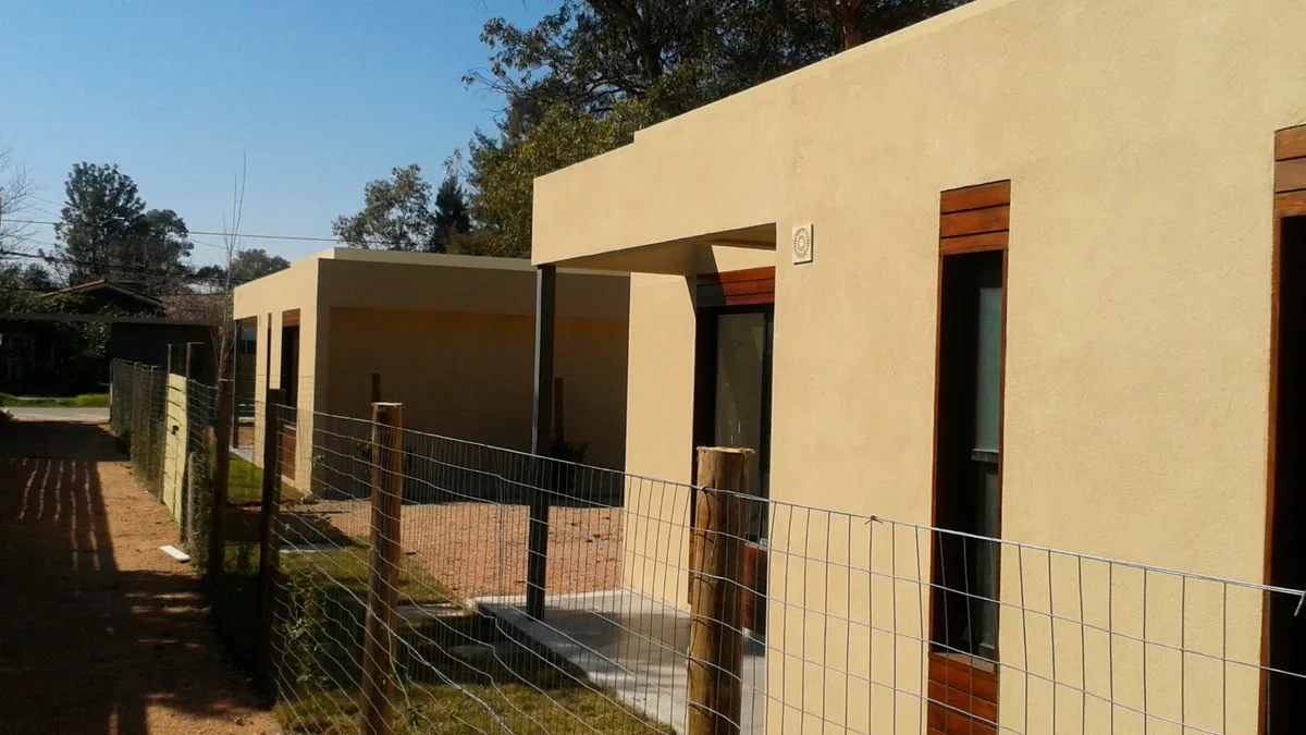 Vista de los accesos y fachadas de las viviendas de Solymar desde el recorrido exterior.