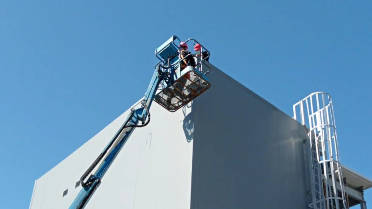 Trabajo en altura sobre la esquina de Macromercado San Martín desde una plataforma elevadora.