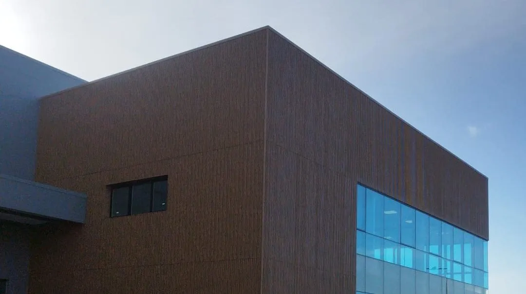 Esquina del edificio Santa Bárbara, con revestimiento de líneas verticales y paños vidriados.