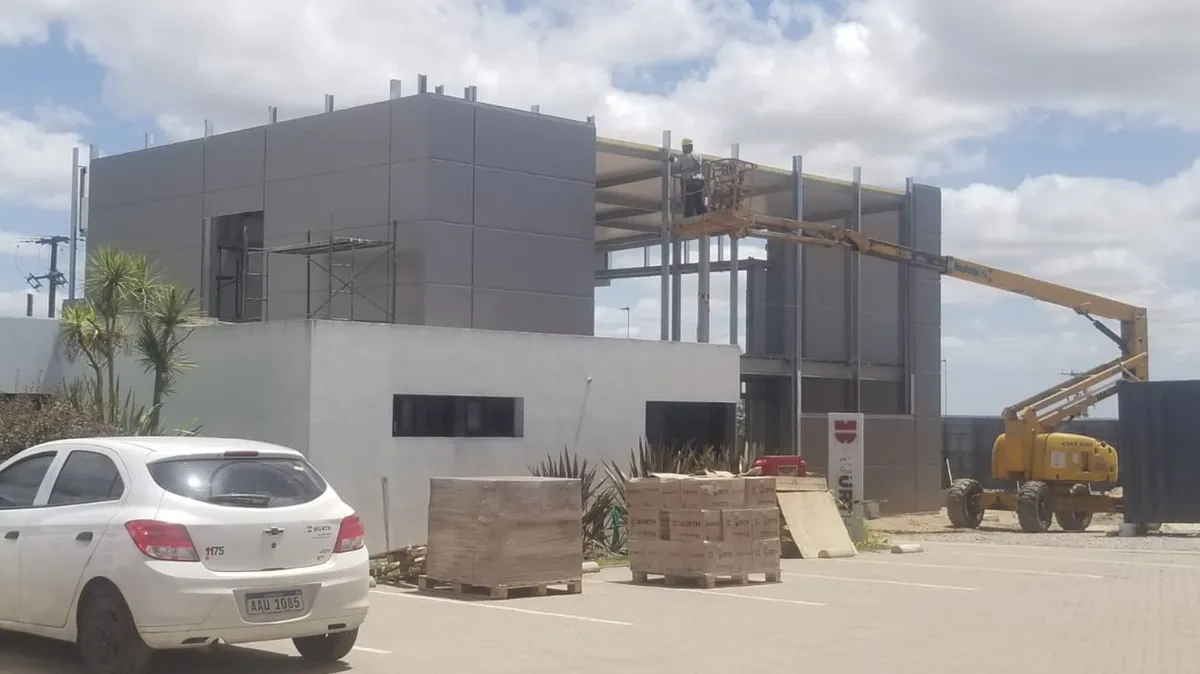 Casa central Würth durante la ejecución, con frente vidriado, plataformas elevadoras y materiales de obra.